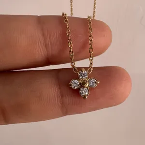 Exquisito collar de trébol dorado con cuatro cristales mostrado para ver el tamaño mini