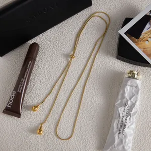 Long collier chaîne serpent dorée avec pendentifs goutte d'eau et perle coulissante