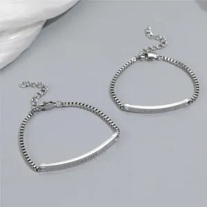 Détail de la gravure you complete me sur les bracelets de couple en acier poli