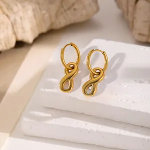 Boucles d'oreilles symbole infini en or poli sur présentoirs blancs épurés
