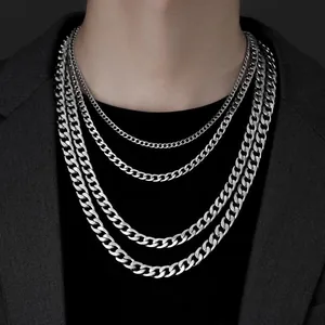 Detail view of four silver Cuban link chains in varying widths on a male model