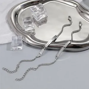 Détail de bracelets de couple avec gravure 'you complete me' et fermoir mousqueton