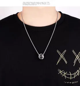 Primer plano de collar hip-hop con colgante de doble anillo y diamantes en modelo