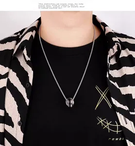 Primer plano del collar con colgante de triple anillo y patrón de tablero de ajedrez