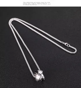 Detalle del colgante de triple anillo entrelazado con diseños negros y de cuadros