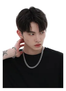 Detail van gepolijste zilveren hiphop-schakelketting en bijpassende armband op een model