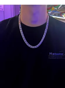 Close-up of polished silver cuban link chain worn by a male model for street fashion style