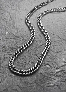 Macro close-up of heavy silver cuban link chain showing polished steel texture