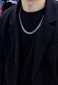 Detailed view of silver Cuban link chain necklace in titanium steel on male model clothing