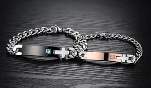 Detail of couples titanium steel bracelets with cubic zirconia and cross patterns