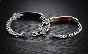 Close-up of titanium steel couple bracelets with black and rose gold cross plates
