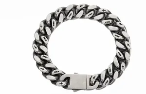 Detail of matte Cuban link bracelet with engraved cross and Holy text on hip-hop steel