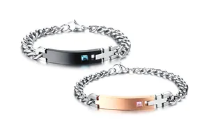 Close-up of titanium steel couple bracelets with cross charms and square zircon stones