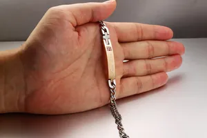 Macro view of rose gold plate with True Love engraving and pink zircon on a steel chain