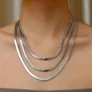 Close-up of triple-layered silver flat snake bone chain necklace in polished steel