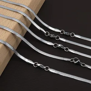 Detailed view of silver flat snake bone chains with lobster clasps on textured background
