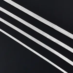 Macro view of four various widths of silver herringbone chains on a black background