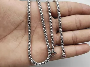 Detail of silver stainless steel box chain necklace with lobster clasp in hand