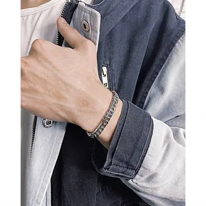 Close-up of a silver-toned hip-hop Cuban link bracelet for men on a wrist