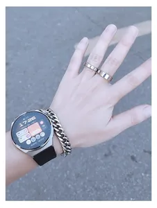Close-up of hip-hop silver curb chain watch band and minimalist rings on wrist