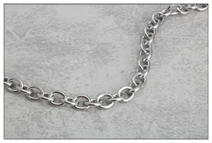 Nahaufnahme der polierten Edelstahl-Gliederkette mit silbernem Finish auf Stein-Hintergrund