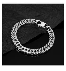 Detail of silver Cuban link bracelet with lobster clasp on dark textured background
