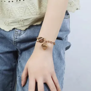 Close-up of rose gold heart charm bracelet with toggle clasp and Proverbs 4:23 engraving