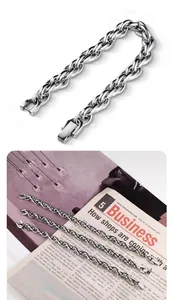 Detail eines silbernen Titanstahl-Seilkettenarmbands mit sicherem Faltverschluss für Herren