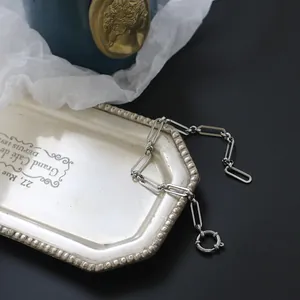 Detail eines silbernen Büroklammer-Kettenarmbands mit rundem Federringverschluss