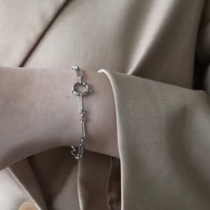 Detailaufnahme des gemischten Silber-Kettenarmbands mit Karabinerverschluss am Handgelenk