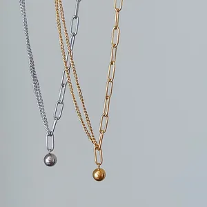 Detalle de collares chapados en oro de 18K y plata con cadena clip y colgante de bola