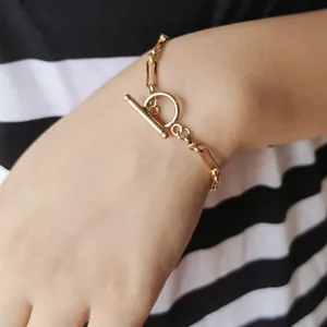 Minimalist gold-tone bamboo chain necklace with OT toggle clasp worn on striped clothing