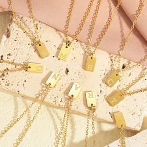 Macro shot of 18K gold plated stainless steel square pendant necklaces with letter engravings