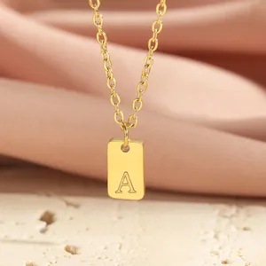Close-up of letter A gold rectangle pendant on chain with a satin fabric background