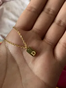 Detailed shot of a 18K gold-plated square pendant necklace with an engraved letter D
