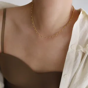 Nahaufnahme der 18K vergoldeten Perlenkette am Model mit minimalistischem Quasten-Design
