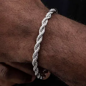 Close-up of a silver twisted rope chain bracelet on a wrist highlighting metal texture