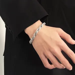 Détail rapproché d'un bracelet en chaîne tissée en acier titane argenté au poignet