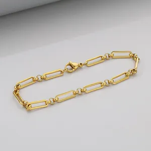 Detail of a gold-plated paperclip chain bracelet featuring a secure lobster clasp