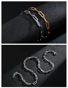 Catene a maglia a graffetta argento e oro con chiusura a moschettone su fondo nero