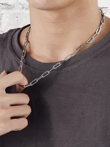 Primo piano della collana minimalista a maglie d'argento indossata su una maglia grigia