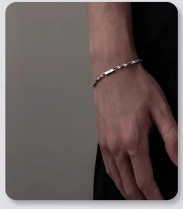 Gros plan du bracelet Mobius minimaliste en acier titane sur un poignet masculin