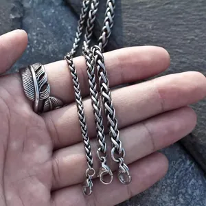 Three different thicknesses of silver wheat chains with lobster clasp on stone background
