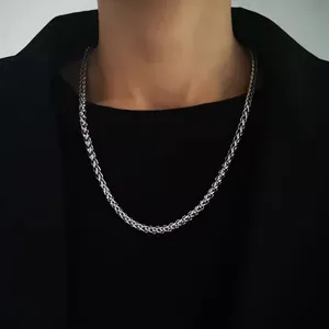 Close-up of 5mm silver wheat chain necklace worn by a man in a black formal suit
