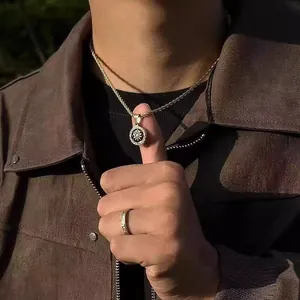 Detail of a vintage golden coin pendant necklace and matching ring on a male model