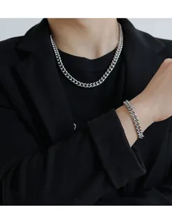 Polished silver Cuban link necklace and bracelet set shown on male model in black suit