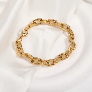Detail eines goldenen Edelstahlarmbands mit spiralförmigen Gliedern und Karabinerverschluss