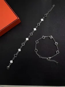 Detail of silver titanium steel bracelets with black and white cross charms on a textured background