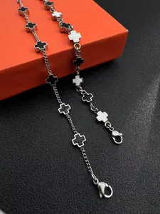 Macro shot of silver titanium steel cross bracelet on an orange and black luxury box