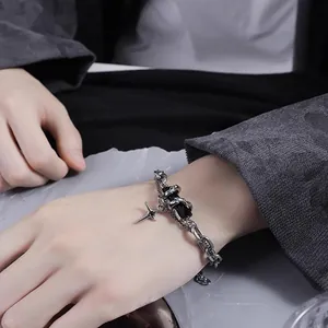 Vue détaillée d'un bracelet chaîne argentée avec pierre noire et pendentif étoile